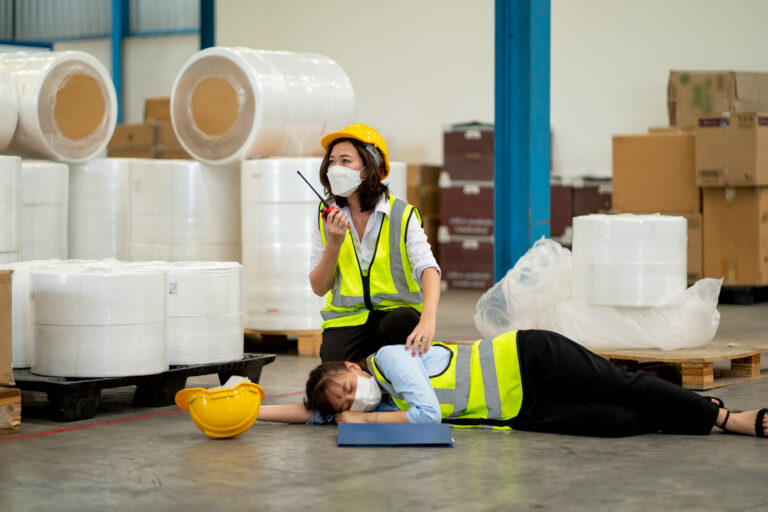 Factory worker woman use walkie talkie ask help to support and save her coworker who faint and lie down on floor during work